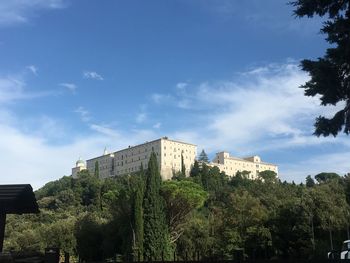 Low angle view of trees and buildings against sky