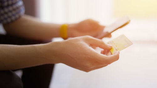 Cropped hands of woman using mobile phone