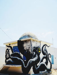 Close-up of statue against graffiti wall