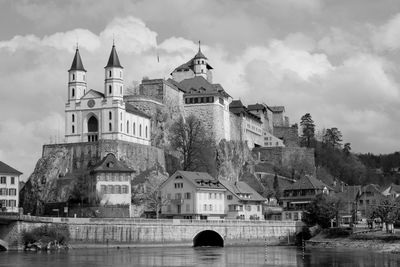 Arch bridge over river against buildings in city