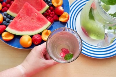 High angle view of hand holding fruits on table