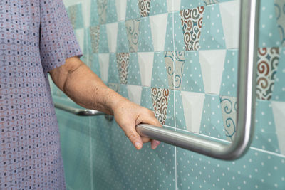 Midsection of woman standing against wall