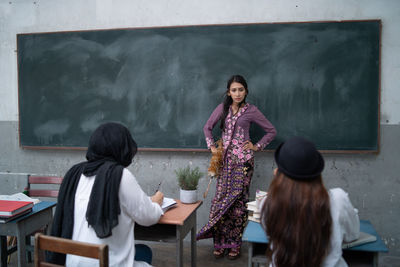 Angry teacher looking at students in classroom