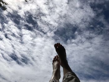 Low section of man against cloudy sky