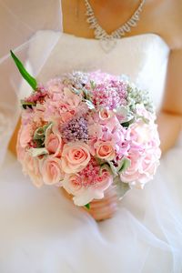 Midsection of bride holding flower bouquet