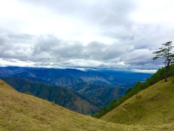 Scenic view of mountains against cloudy sky