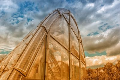 Low angle view of glass building against sky