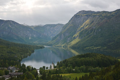 Scenic view of lake and mountains against cloudy sky