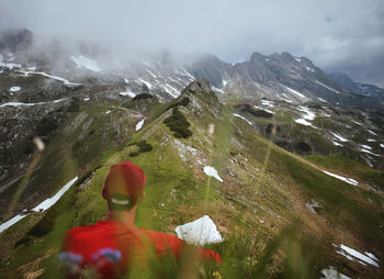 Rear view of man on mountain against sky