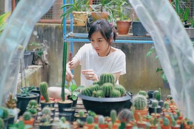 Woman looking at potted plant