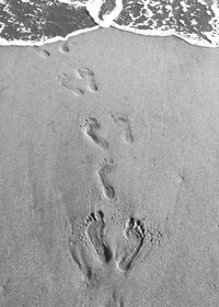 High angle view of footprints on sand at beach