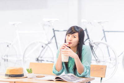 Portrait of a young woman sitting on table