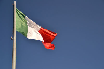 Low angle view of italian flag against blue sky