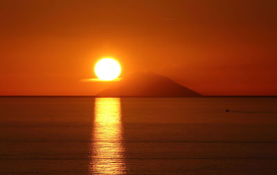 Scenic view of sea against romantic sky at sunset