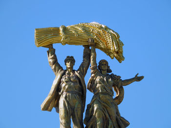 Low angle view of statue against clear blue sky