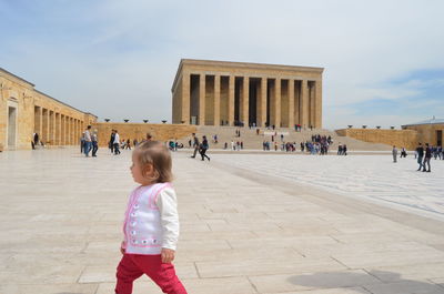 Cute girl walking at historic building