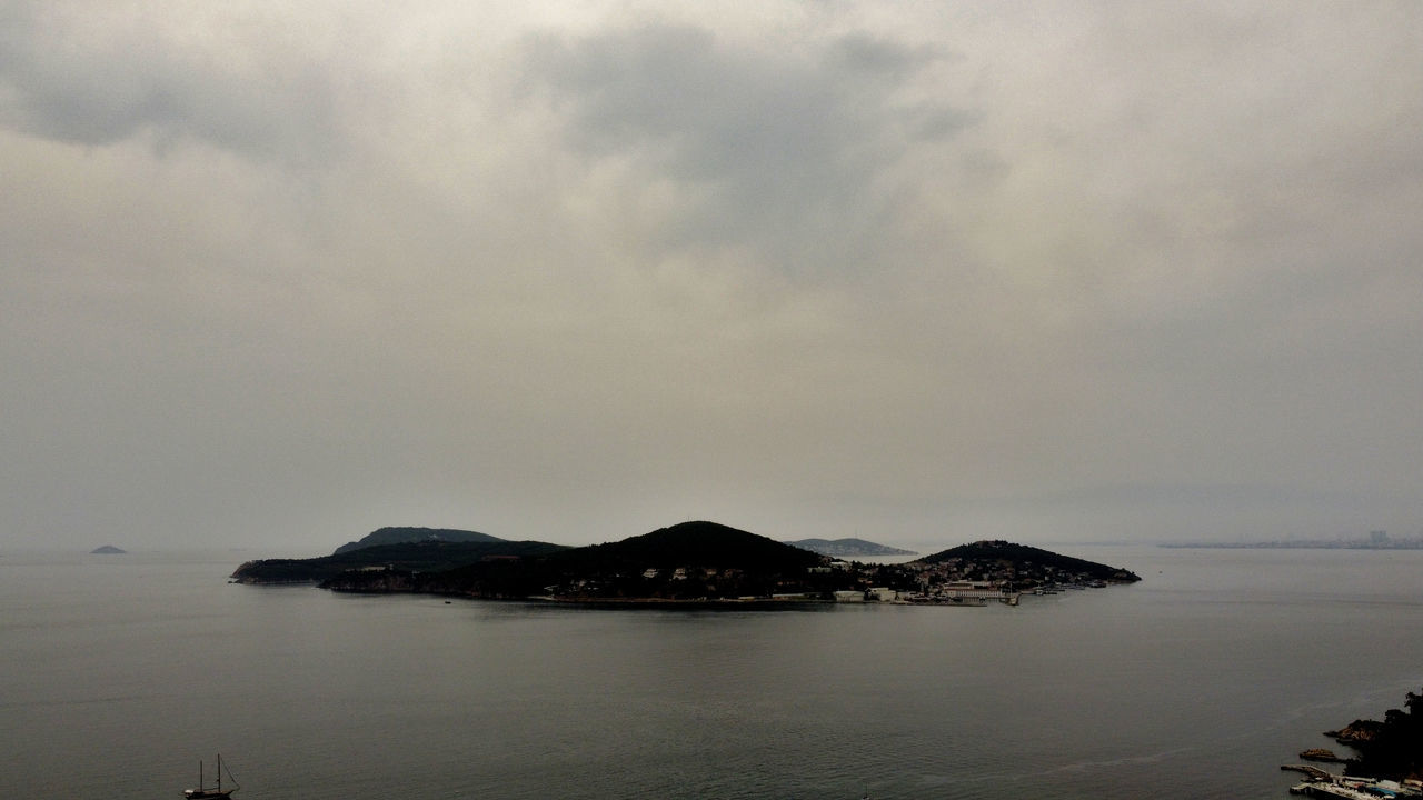 SCENIC VIEW OF SEA BY MOUNTAIN AGAINST SKY