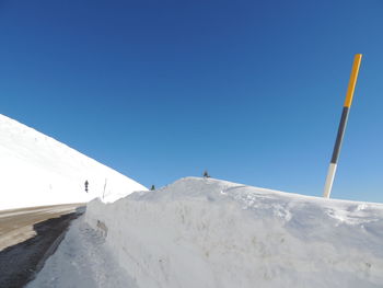 Low angle view of snowcapped mountain against clear blue sky