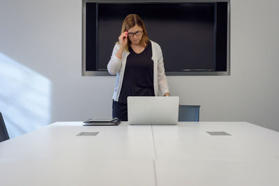 Mid adult woman using laptop on table