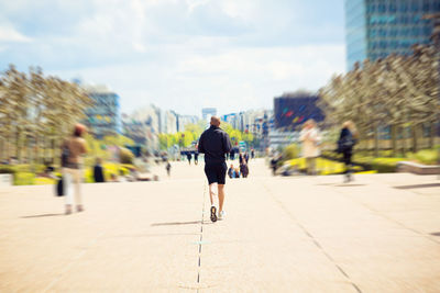 Rear view of man walking on street in city