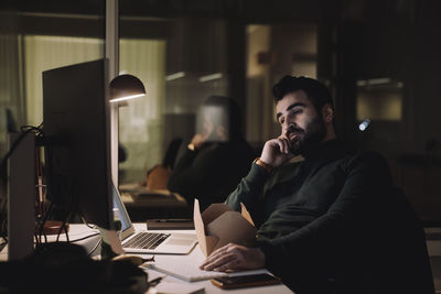 Businessman working on computer last minute in office at night