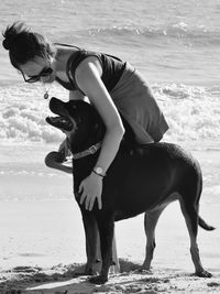 Full length of woman on beach with a dog