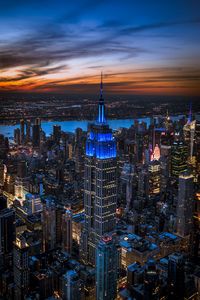 Illuminated cityscape against sky during sunset