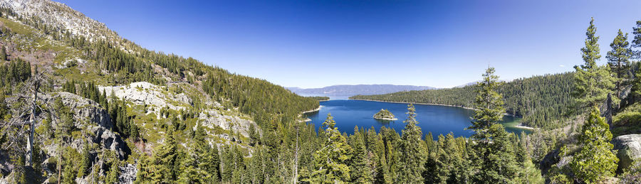 Scenic view of lake and mountains against clear blue sky