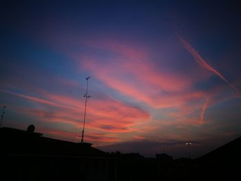 Low angle view of silhouette communications tower against sky during sunset