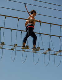 Low angle view of boy swinging ride against clear sky