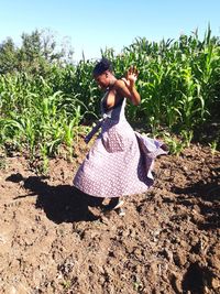 Woman with arms raised on field