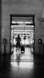 Rear view of man walking in subway station