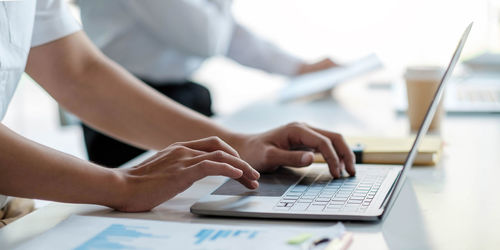 Midsection of man using laptop on table