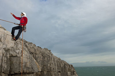 Female climber rappelling of seacliff in swanage / england