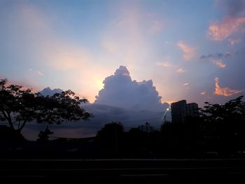 Silhouette trees and buildings against sky during sunset