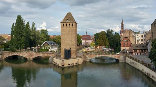 Arch bridge over river against buildings in city