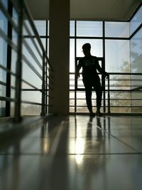 Rear view of silhouette man standing in corridor