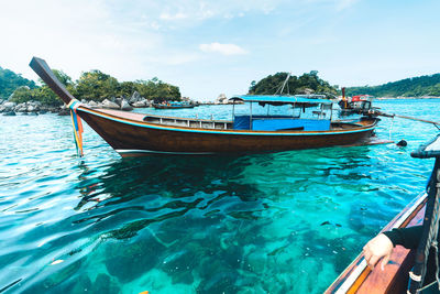 Scenic view of fishing boat moored in sea against sky