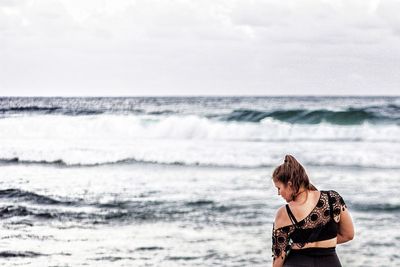 Man standing in sea against sky