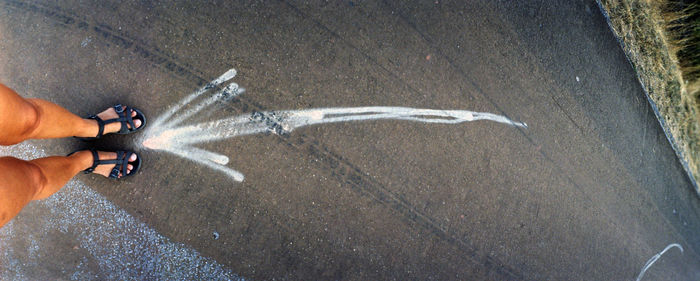 Low section of man skateboarding on road