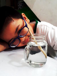 Portrait of man drinking glass on table