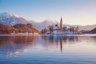 Scenic view of lake by buildings against sky