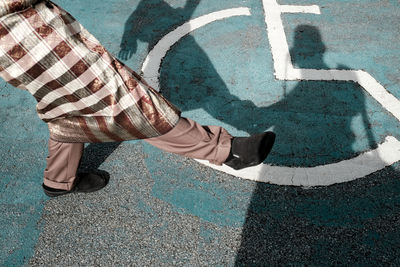 Low section of man lifting leg on road