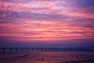 Pier on sea against cloudy sky