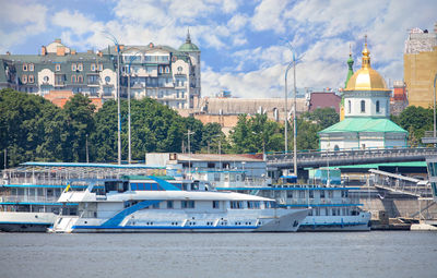 River trams are moored on the embankment of the dnipro against the backdrop of the christian church 