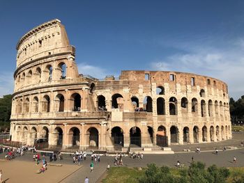 Group of people in front of historical building against sky