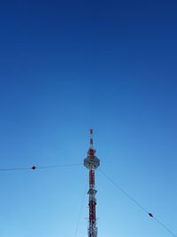 Low angle view of communications tower against clear blue sky