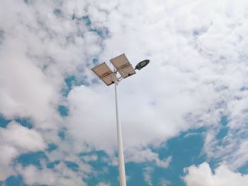 Low angle view of floodlight against cloudy sky