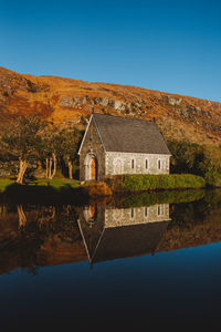 Gougane barra church in the morning with reflection in water 