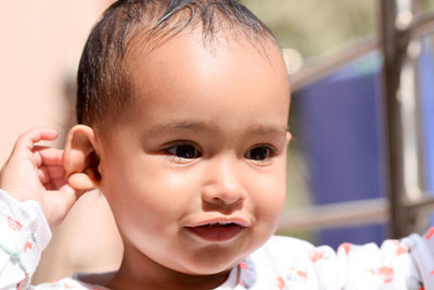 Close-up of cute baby girl looking away